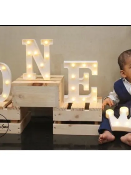 A little prince celebrating his first birthday with our light up props. The large 'ONE' marquee letters and illuminated crown create a perfect photo opportunity for this milestone.