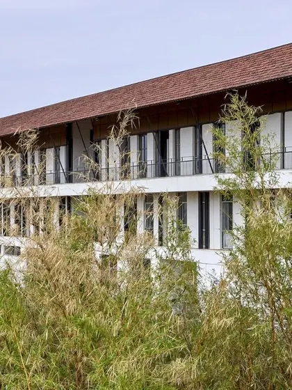 The facade of Sparkrill International School, showing how the building sits within the landscape. We use natural materials and thoughtful orientation to ensure our educational buildings are energy-efficient and provide a healthy environment for students.