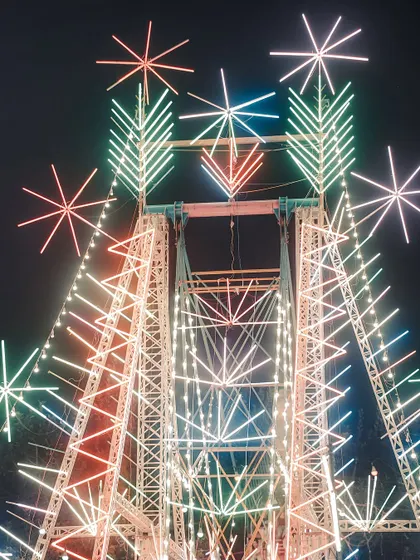 A photo series from a local fair or 'mela'. These images capture the nostalgic charm of simpler times, with ferris wheels, street food stalls, and colorful toys under the night sky.