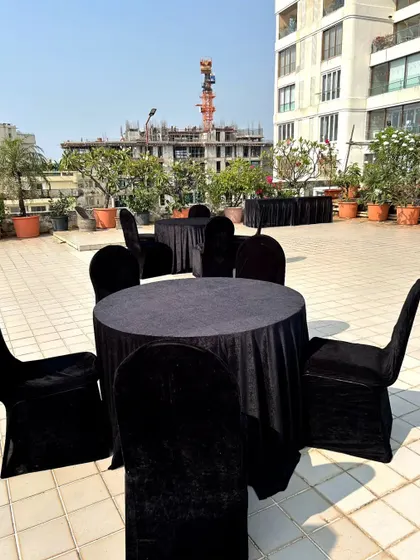 Another angle of the Diwali party terrace setup, showing the arrangement of tables in the open air space with a view of the city.
