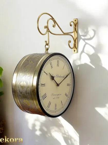 Our vintage-style station clock in a brass finish, featuring a double-sided face and an elegant, wall-mounted bracket.