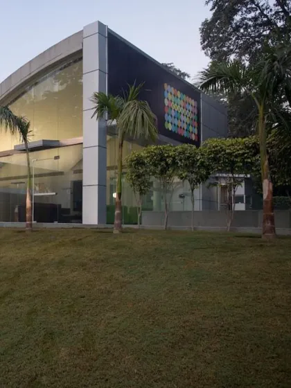 The exterior of our adaptive reuse project in Okhla. We retained the industrial shed's form but modernized the facade with a large glass entrance and a colorful art installation, signaling the creative and collaborative work happening within.
