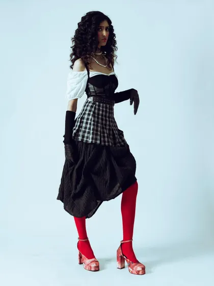 A full-body pose that emphasizes the unique silhouette and styling of the vintage-inspired outfit.