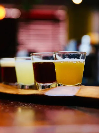 Another angle of the beer tasters, this time with a shallower depth of field. This artistic shot draws the eye to the first glass while hinting at the other flavors, creating a sense of discovery.