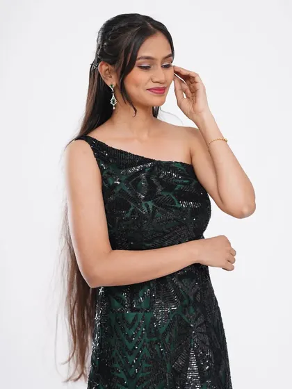 A chic and modern black one-shoulder sequin gown. The simple silhouette is elevated by the sparkling fabric, making it a great choice for a cocktail party.