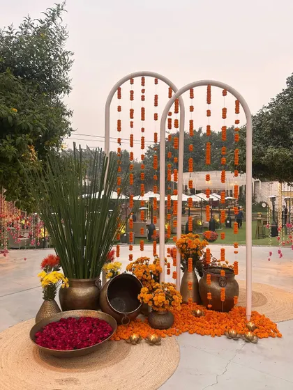 A beautiful photo-op corner with marigold curtains and traditional brass pots, perfect for a Mehendi.