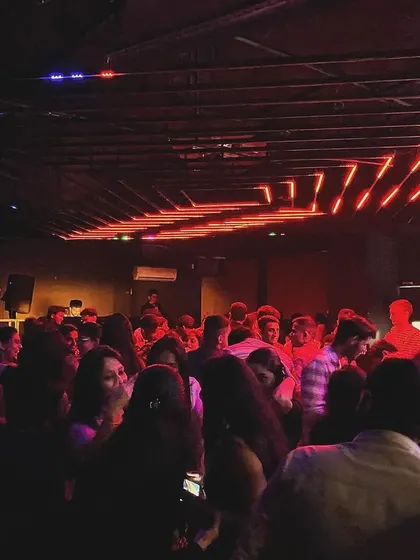 The red-lit dance floor at Unicorn House during a high-energy set.