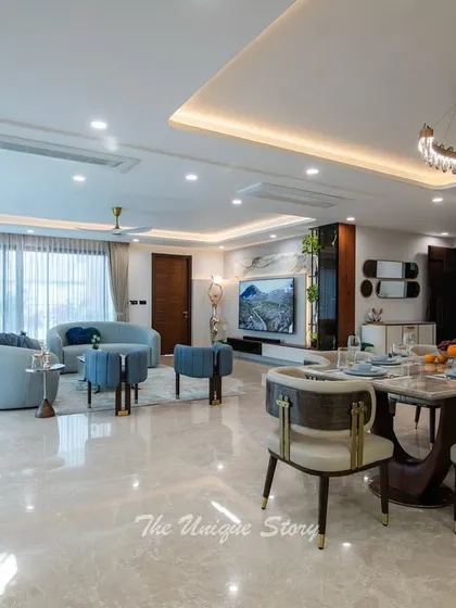 Another perspective of the open-plan space, looking from the dining area towards the living room. The curved pastel sofas and large windows create a bright and welcoming seating area, perfect for family gatherings.