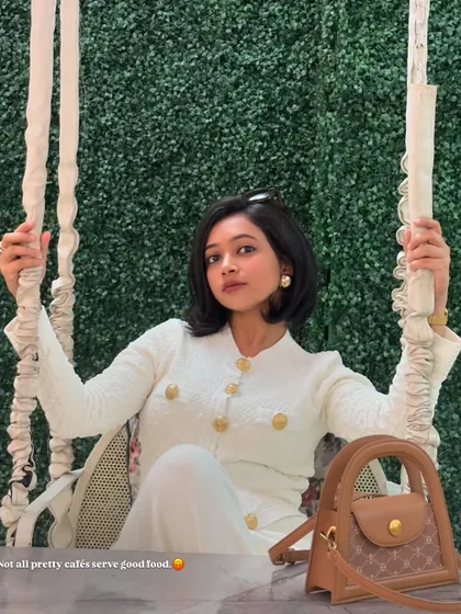 A chic all-white look for a cafe visit. This textured cardigan and pants set with gold buttons has a very classic and elegant feel.