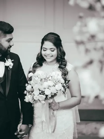 A gentle black and white portrait of the couple after their ceremony. The soft focus on the foreground flowers adds a romantic touch.