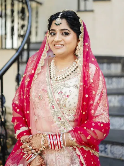 This bride was a vision for her sunset wedding. Her makeup features a soft smokey eye and a neutral lip, balanced with a detailed hair updo, creating a look of pure elegance.