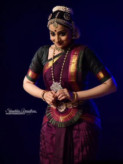 A gentle, poised moment captured during a photo shoot, reflecting the grace of the dance form.
