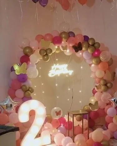 A wider view of the butterfly-themed birthday, including a large light-up number '2'.
