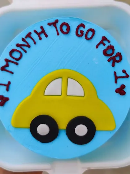 "1 month to go for 1." A cute countdown bento cake with a little yellow car to celebrate 11 months.