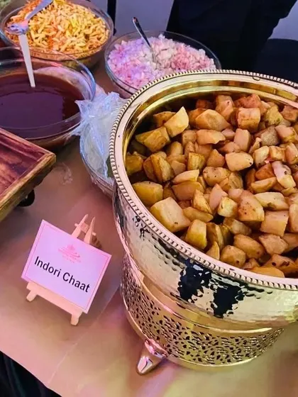 We bring regional specialties to you. This is our Indori Chaat live counter, featuring fried potato cubes ready to be mixed with chutneys, onions, and sev for a tangy and savory snack.