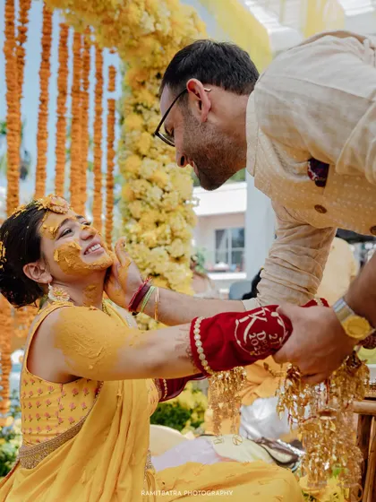 A playful and intimate moment between the bride and groom during their Haldi ceremony at a beach resort in Thailand.