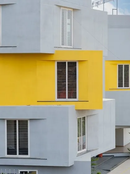 The facade of a CBSE School in Bengaluru, where symmetry and color are used to create a playful yet orderly learning environment. The projecting window bays in grey and yellow add a sense of rhythm to the building.