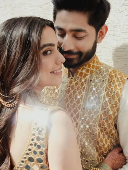 A beautiful close-up of the couple, capturing the bride's radiant smile and the intricate details of their Mehndi outfits.