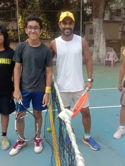 A coach poses with some of our promising junior players during a tournament. We believe in guiding our students through every step of their competitive journey.