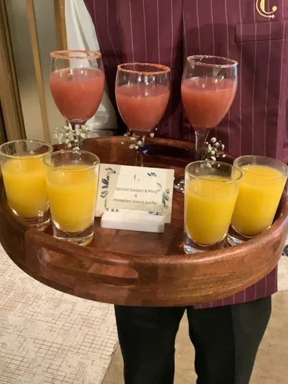 A server presenting a tray of our colourful mocktails. Our professional service ensures that guests are welcomed with a refreshing beverage upon arrival.