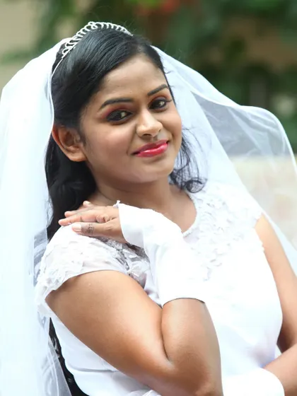 A portrait of a smiling Christian bride in her white gown and veil.
