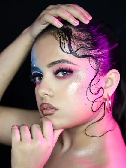 A profile shot that highlights the wet-look hairstyle and the glossy, vibrant makeup.
