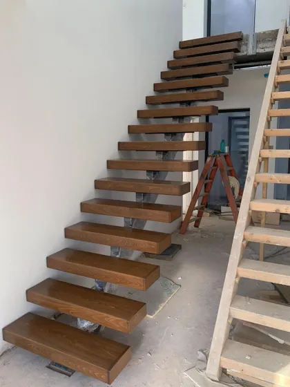 The floating staircase is installed before the final flooring is laid, ensuring a clean integration with the finished surfaces.