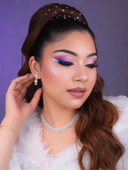 The pearl-studded hairband adds a touch of elegance and balances the bold, creative eye makeup.