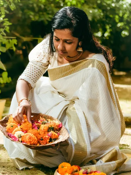 A portrait of me in a traditional Kerala saree, gathering flowers for Onam celebrations. This adds a personal touch to my festive work.