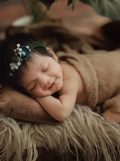 A close-up of a sleeping newborn, showing their delicate features and peaceful expression. These are the details you'll want to remember forever.