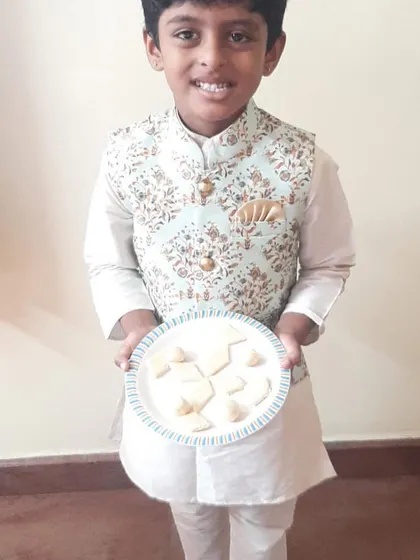 This student is happy to display the sweets he made. Completing a recipe from start to finish gives children a powerful sense of capability and confidence.