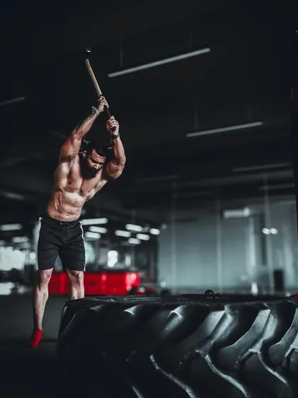 An action shot of a powerful sledgehammer swing. This movement engages the core, obliques, back, and shoulders.