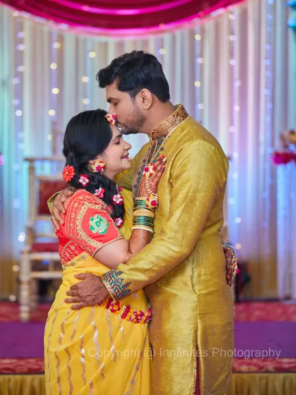 A sweet, tender moment during the pre-wedding festivities. The couple, dressed in coordinated yellow outfits, share a quiet moment of affection.