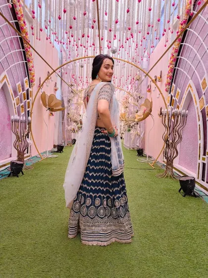 A back view of the client in the navy blue printed lehenga, showing the stylish blouse back.