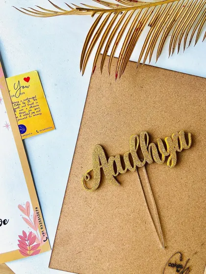 Add some sparkle with our glitter finish! This "Aadhya" name topper in gold glitter is perfect for adding a fun and festive touch to any cake.