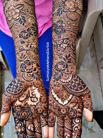 Another view of this stunning floral bridal mehendi. The name 'Aqib' is written in elegant Arabic script, nestled among the flowers on the palm.