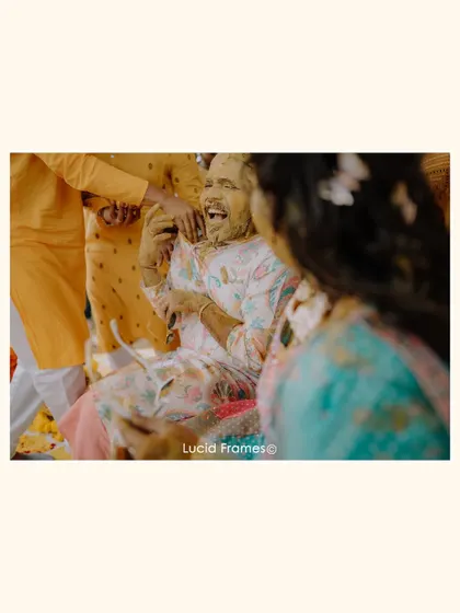 The groom's reaction as he gets covered in Haldi, a moment of pure, unscripted laughter.