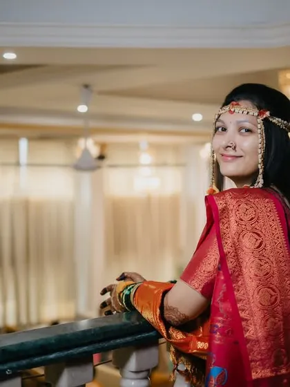 The bride looks back over her shoulder with a sweet smile, a classic and elegant bridal pose.