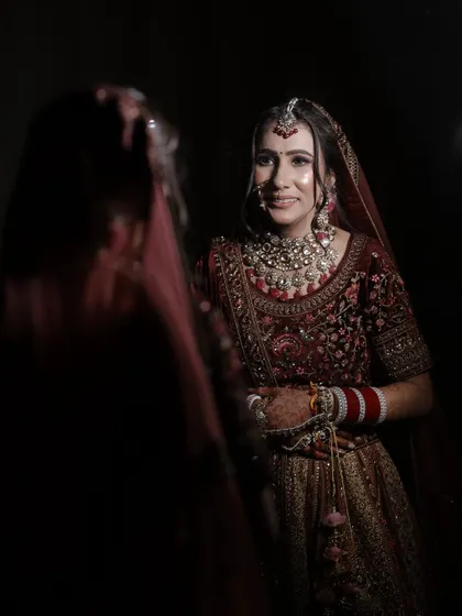 A beautiful portrait capturing the bride's reflection. The lighting highlights her flawless skin and the intricate details of her makeup.