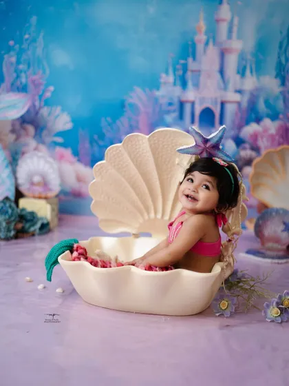 A joyful smile from our little mermaid, sitting happily in her seashell. These fantasy photoshoots are designed to be fun and engaging for your child.