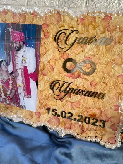 A 12x16 inch frame with a zigzag pearl border. The background is filled with preserved light-colored rose petals, creating a soft and romantic feel.