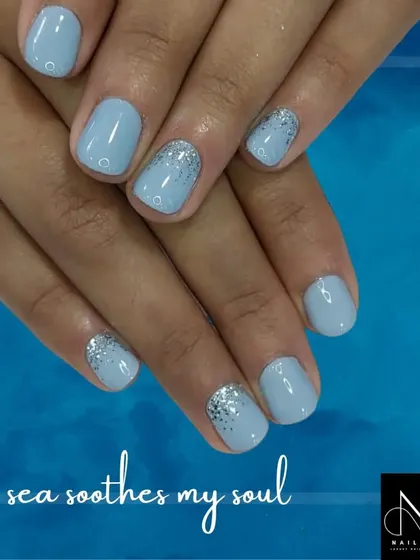 A calming, sea-inspired manicure. We used a soft powder blue polish and added a simple silver glitter fade on the accent nails for a serene and pretty look.