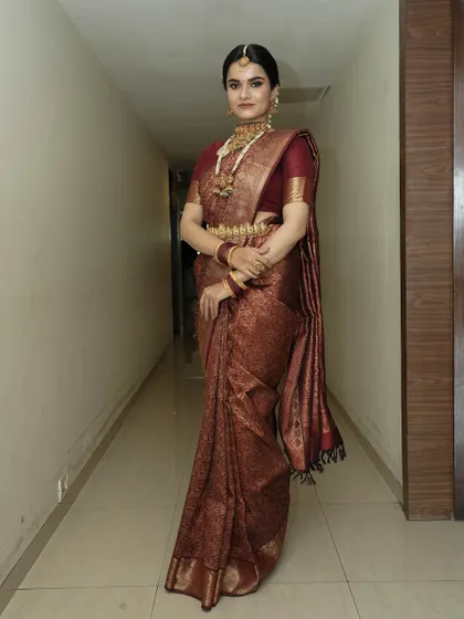 A full-length shot showing the complete traditional ensemble. The makeup is glamorous yet perfectly balanced.