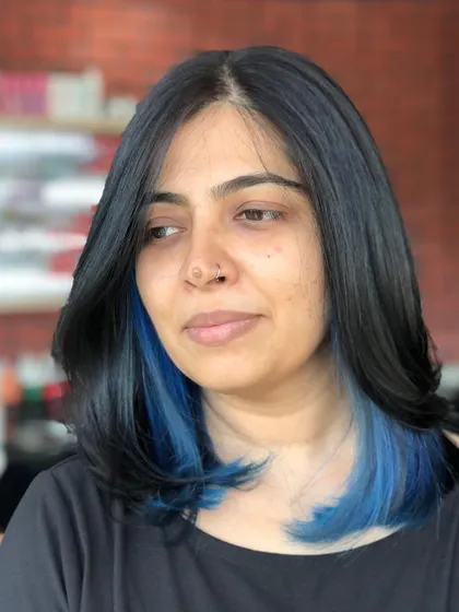 A closer look at the blue peek-a-boo highlights. They add a cool, edgy vibe to the classic black hair.