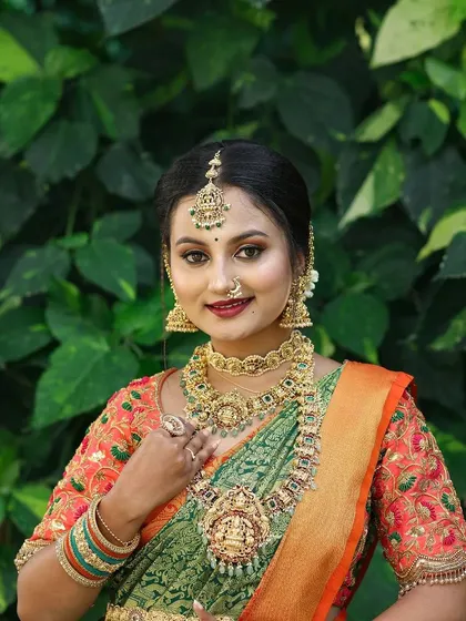 A model looking radiant in a temple jewellery set with a green saree, a classic combination for any South Indian festive occasion.