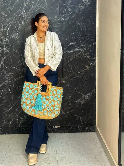 This large crochet and jute tote bag with a bright blue tassel is the perfect beach or resort accessory. Here, I've styled it with a casual cropped jacket and jeans.