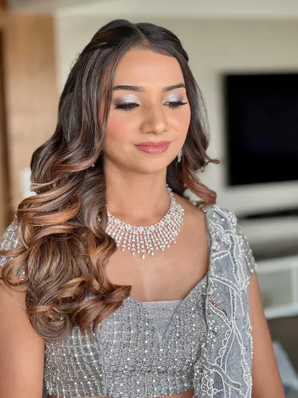 Subtle elegance meets shimmering allure. This look features beautiful silver shimmery eyes, a flawless base, and soft curls, perfect for a reception or cocktail party.