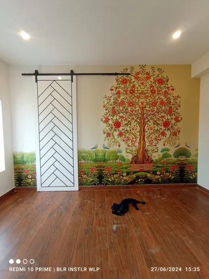 Another view of the 'Tree of Life' mural, showing its placement next to a modern barn door.
