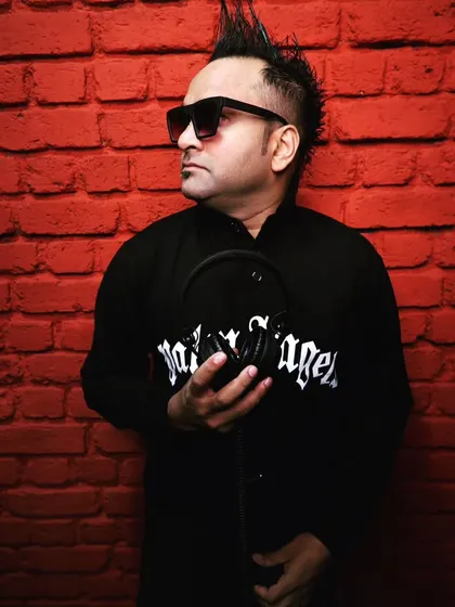 A stylish shot from a recent photoshoot against a red brick background. My look is modern and edgy, just like the music I spin.