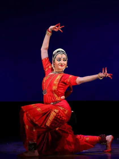 A kneeling pose with arms outstretched, conveying a sense of grace and devotion. This is from a lyrical section of the performance.